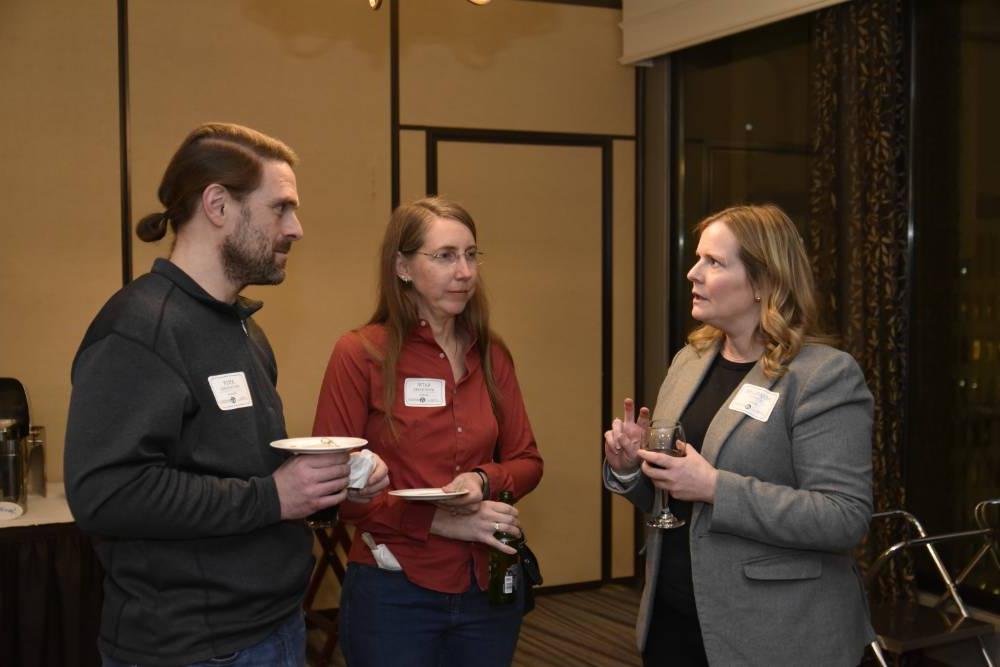 Three alumni talking together at the event.